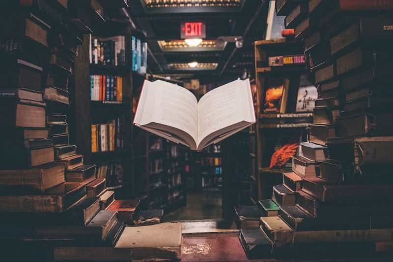 view of floating open book from stacked books in library